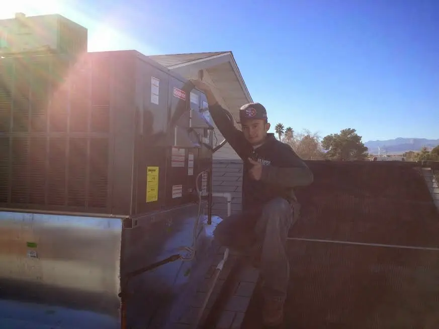 HVAC technician performing Heat Pump Repair on a rooftop unit in Maple Grove